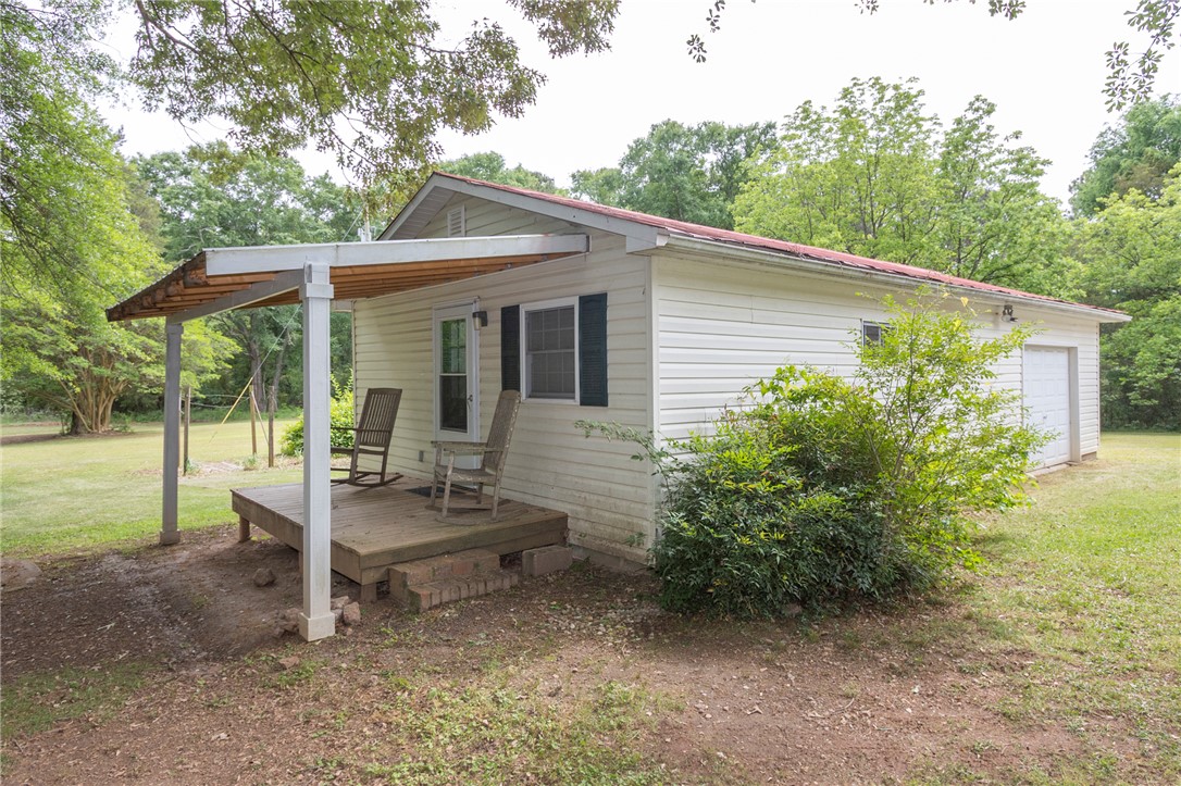 1116 Leatherdale Road Iva, SC 29655 - Photo 15 of 46 This charming home offers a peaceful retreat with its welcoming porch and serene natural surroundings.