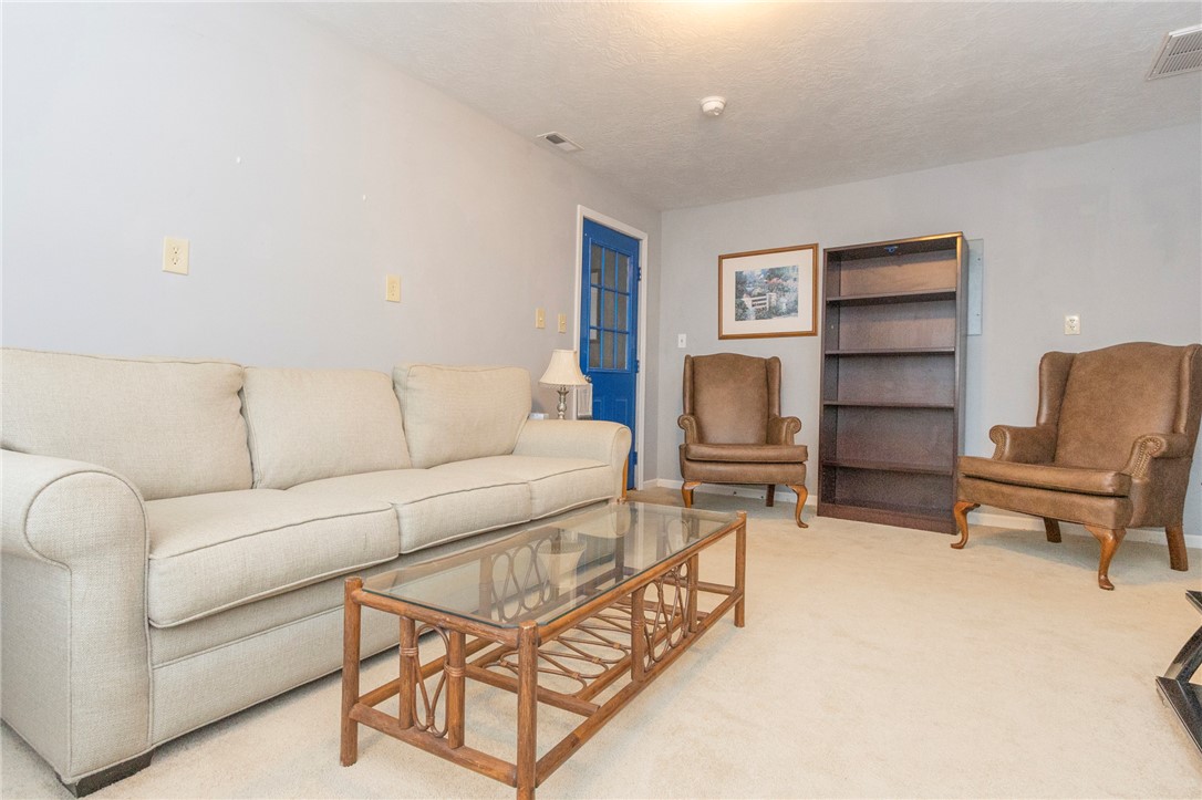 1116 Leatherdale Road Iva, SC 29655 - Photo 17 of 46 This versatile living space features plush carpet flooring and a striking blue door, creating a cozy and inviting atmosphere.