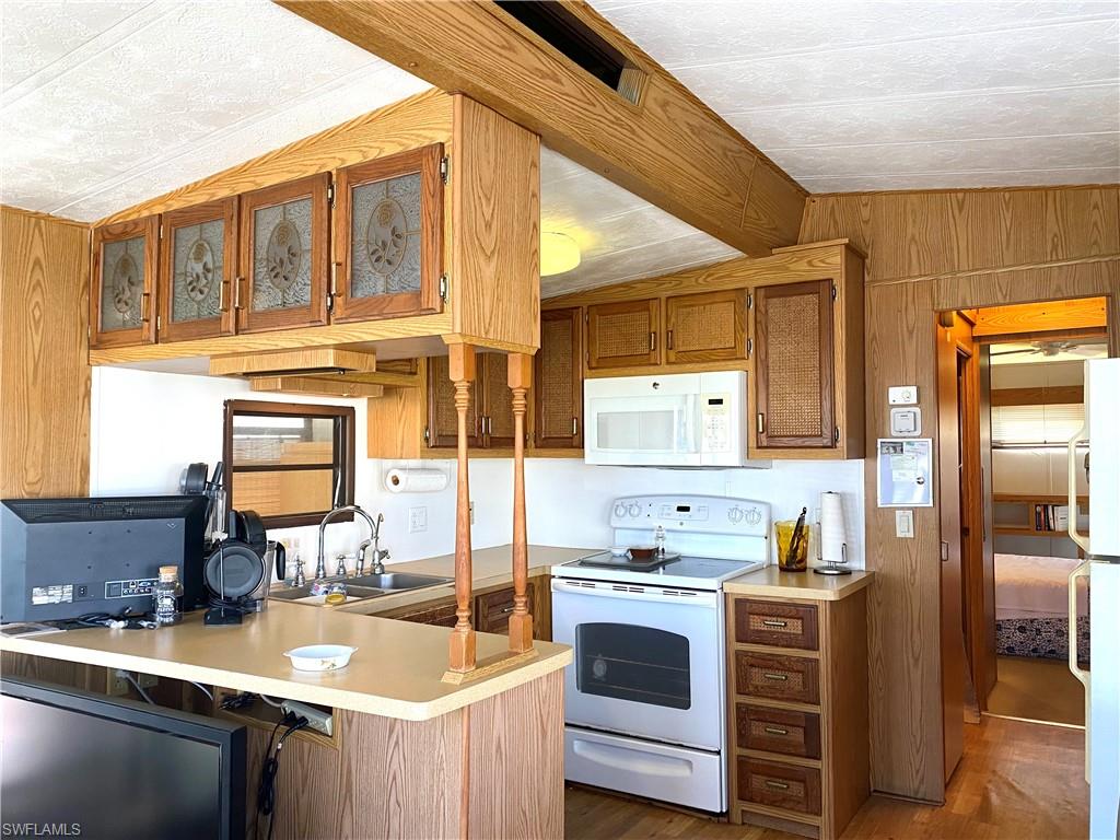 4561 Split Log Lane East Estero, FL 33928 - Photo 5 of 8 a kitchen with granite countertop a sink and a stove top oven