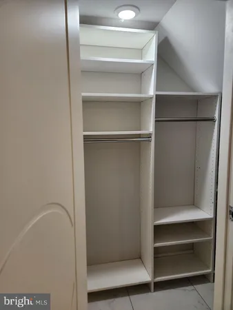 a view of walk in closet with empty racks