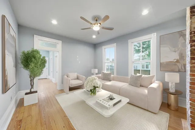a living room with furniture a potted plant and a large window
