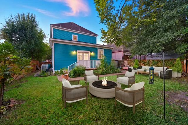 a view of a house with backyard sitting area and garden