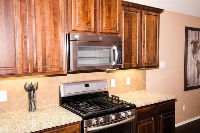 a kitchen with granite countertop a stove and a sink