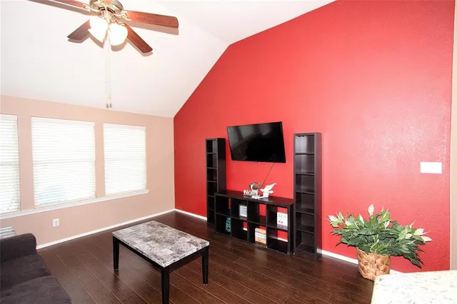 a living room with furniture a flat screen tv and a floor to ceiling window