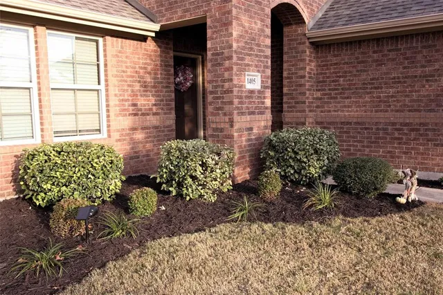 a view of a brick house with a chairs in a patio