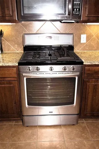 a stove top oven sitting inside of a kitchen