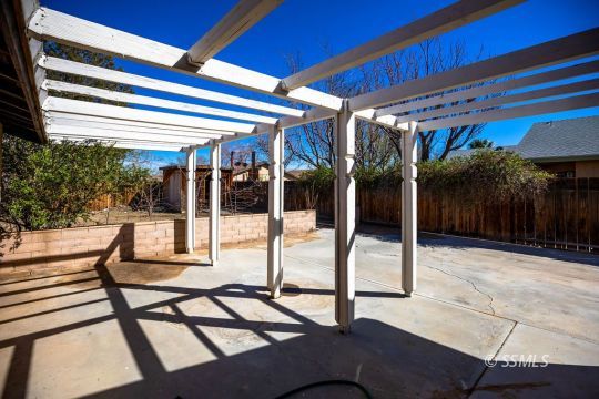 732 South Chesapeake Street Ridgecrest, CA 93555 - Photo 25 of 28 a view of a patio with a table and chairs and floor to ceiling window
