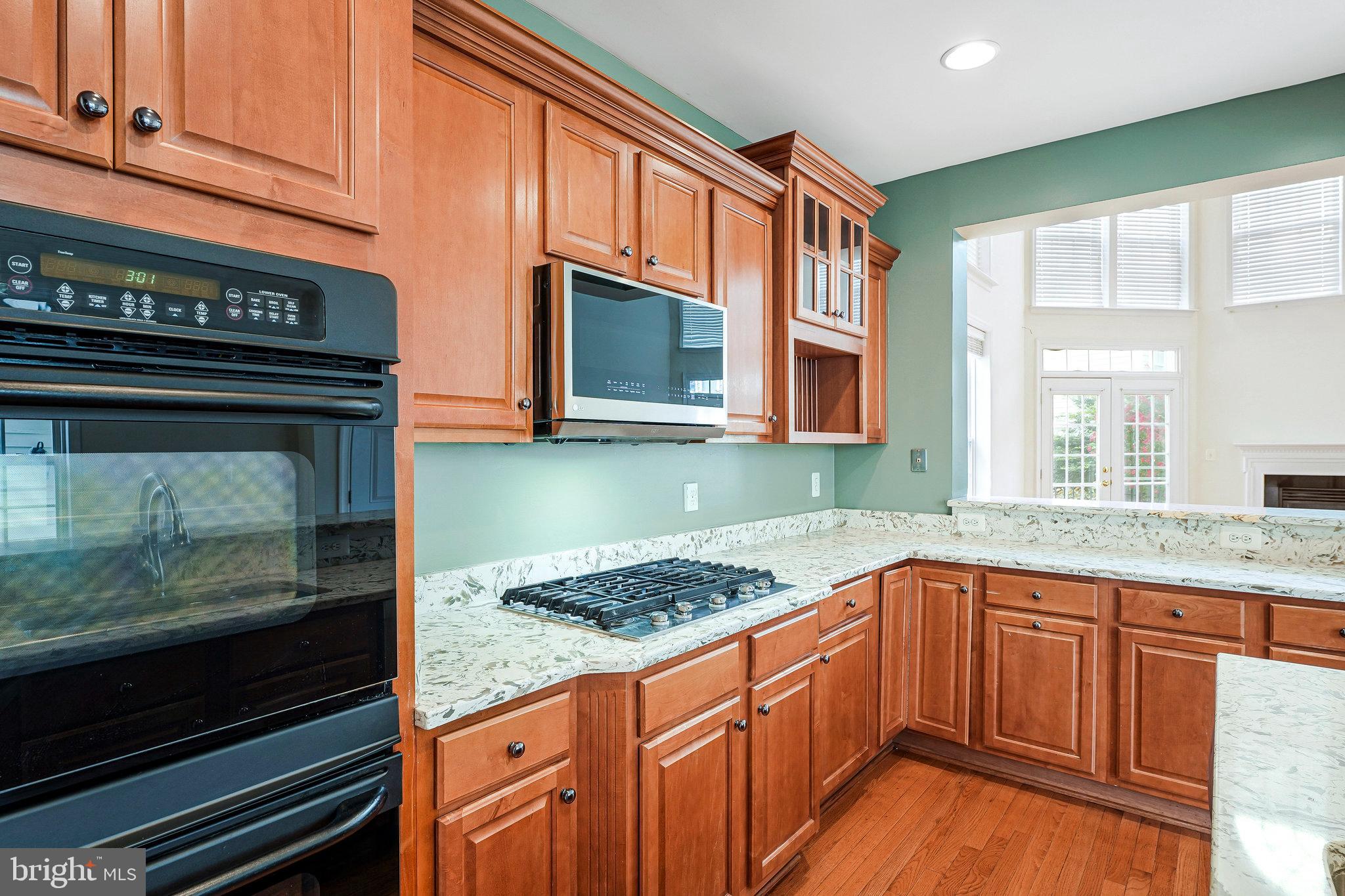 21946 Windover Drive Broadlands, VA 20148 - Photo 11 of 45 a kitchen with stainless steel appliances granite countertop a stove and a microwave