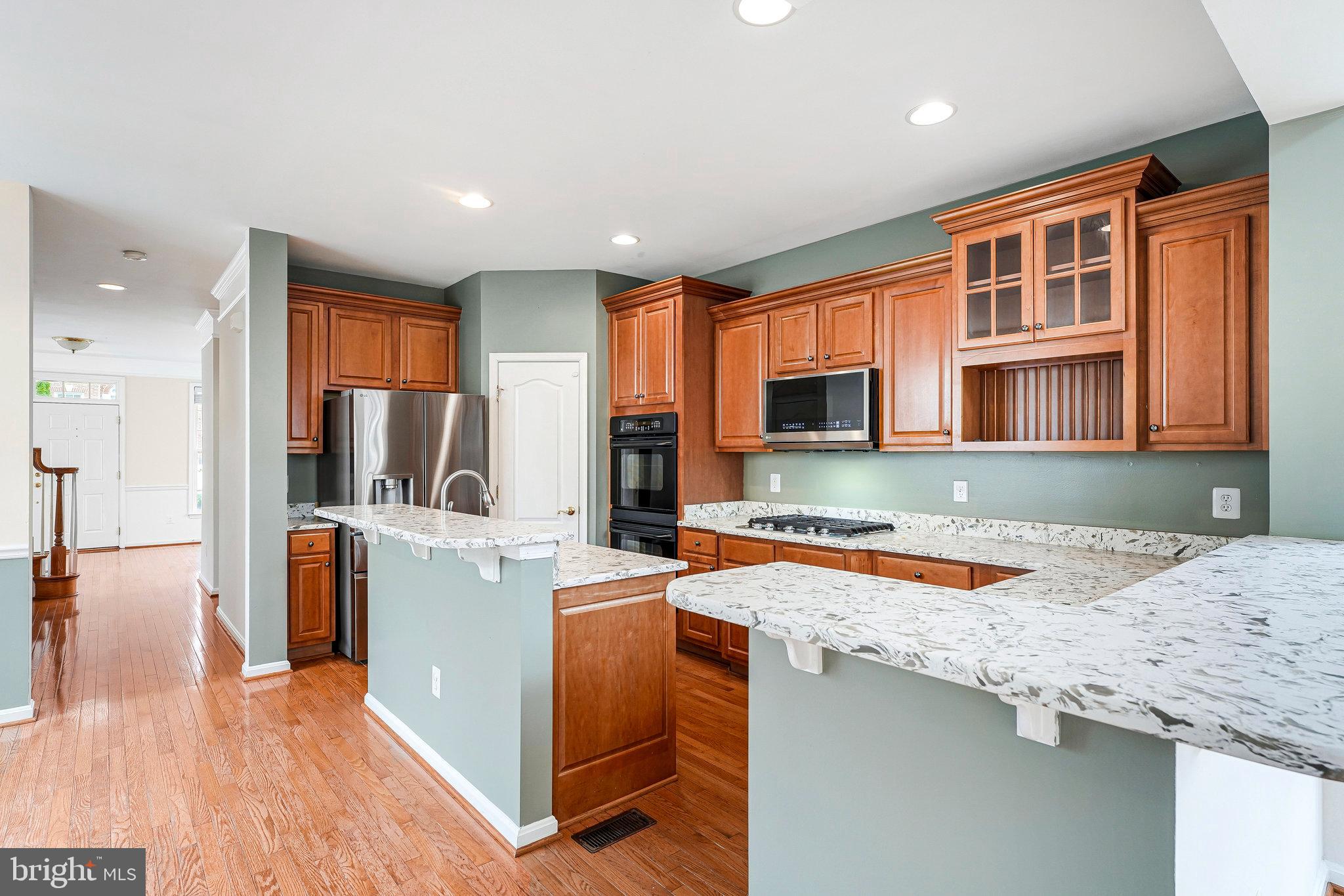21946 Windover Drive Broadlands, VA 20148 - Photo 12 of 45 a kitchen with stainless steel appliances granite countertop a sink stove and refrigerator
