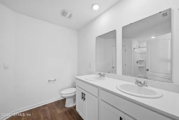 a bathroom with a double vanity sink toilet and a mirror