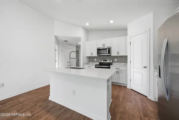 a kitchen with stainless steel appliances a refrigerator sink and microwave