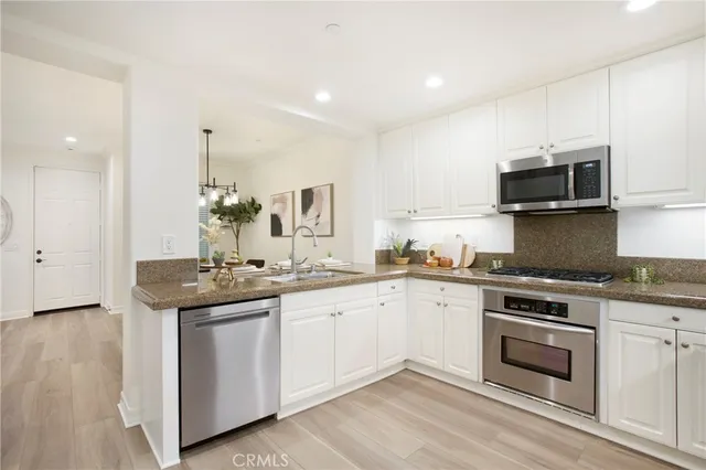 a kitchen with granite countertop a sink and steel appliances