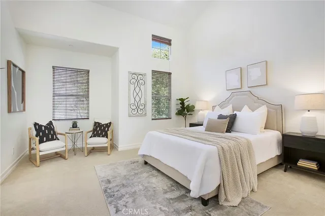 a bedroom with bed and a potted plant on the dresser