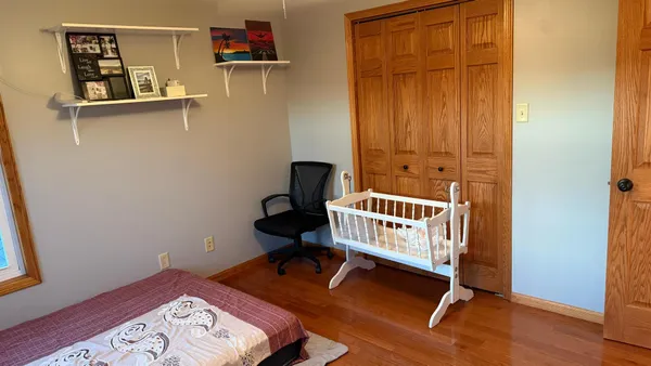 a bedroom with a bed and wooden floor