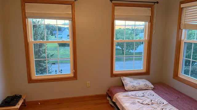 a view of a bedroom with bed and wooden floor