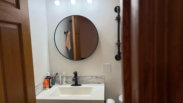 a bathroom with a sink toilet and a mirror