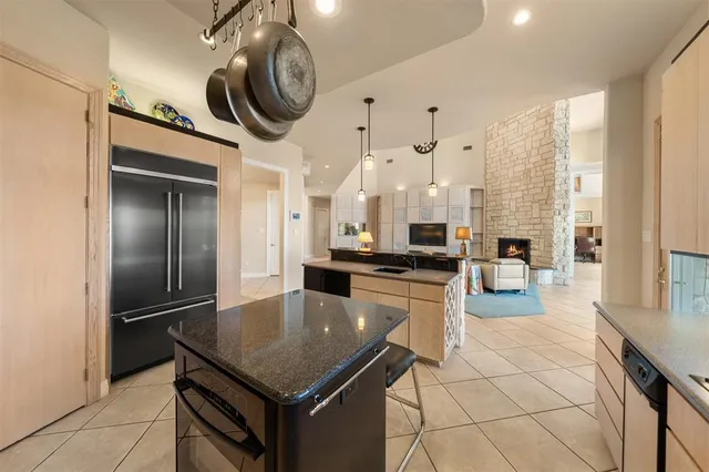 a kitchen with stainless steel appliances granite countertop a sink a stove and a refrigerator
