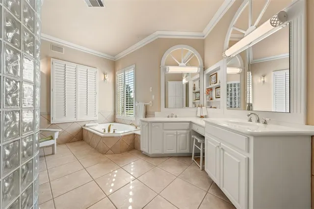 a spacious bathroom with a double vanity sink mirror and bathtub