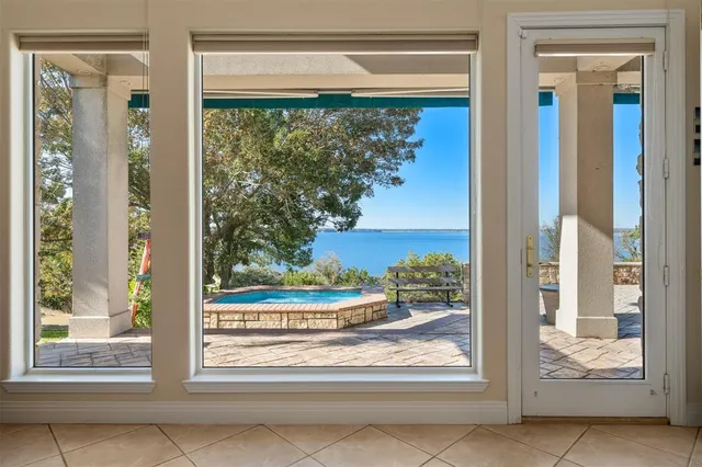 a view of a room that has a large window and front of door