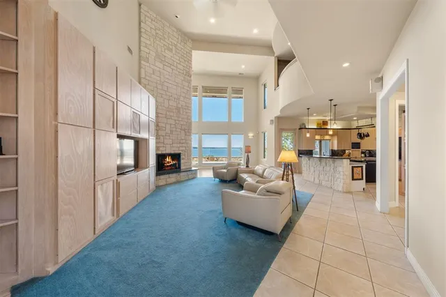 a living room with fireplace furniture and a view of kitchen