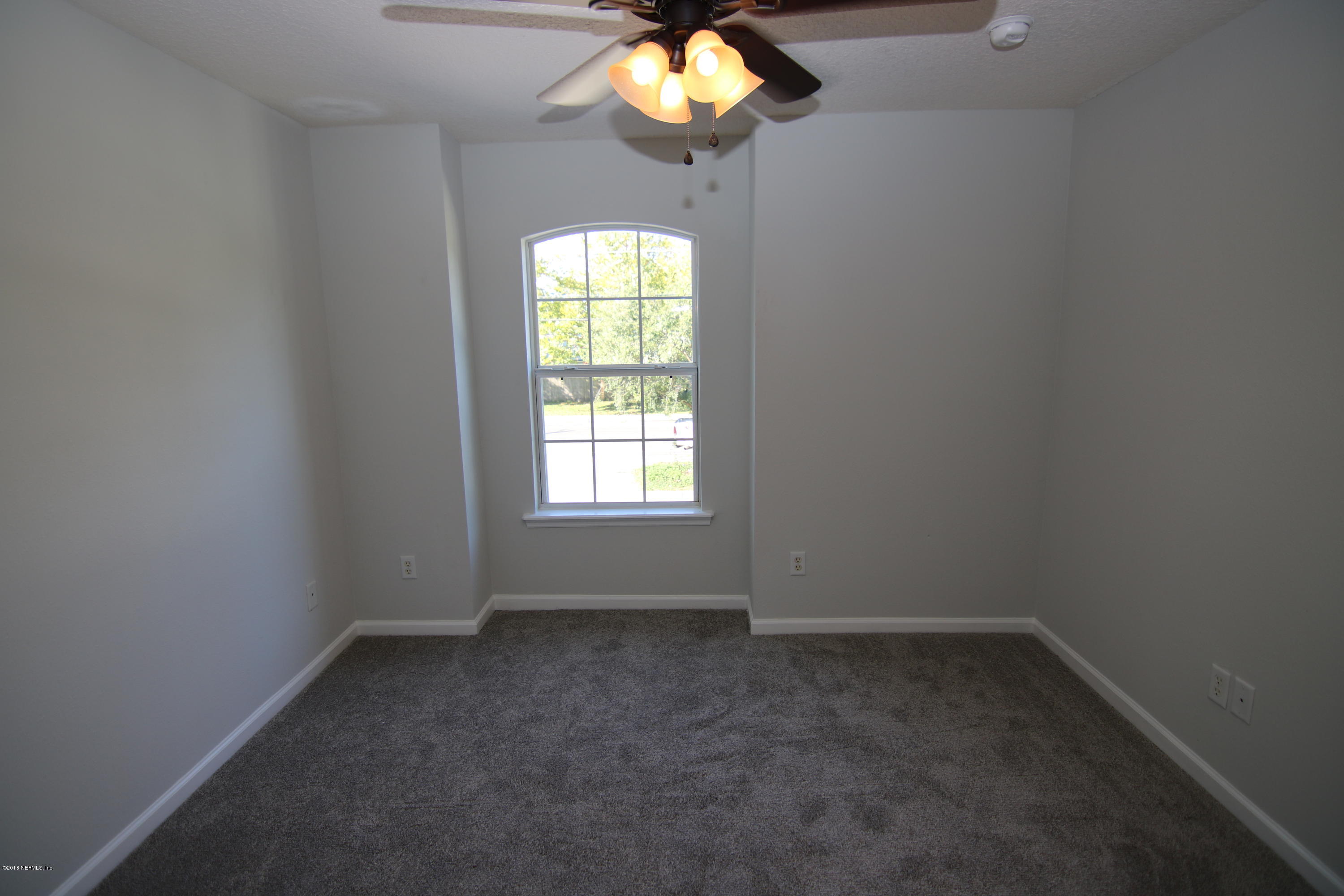 4661 Barnes Road South Jacksonville, FL 32207 - Photo 16 of 22 an empty room with a chandelier fan and window
