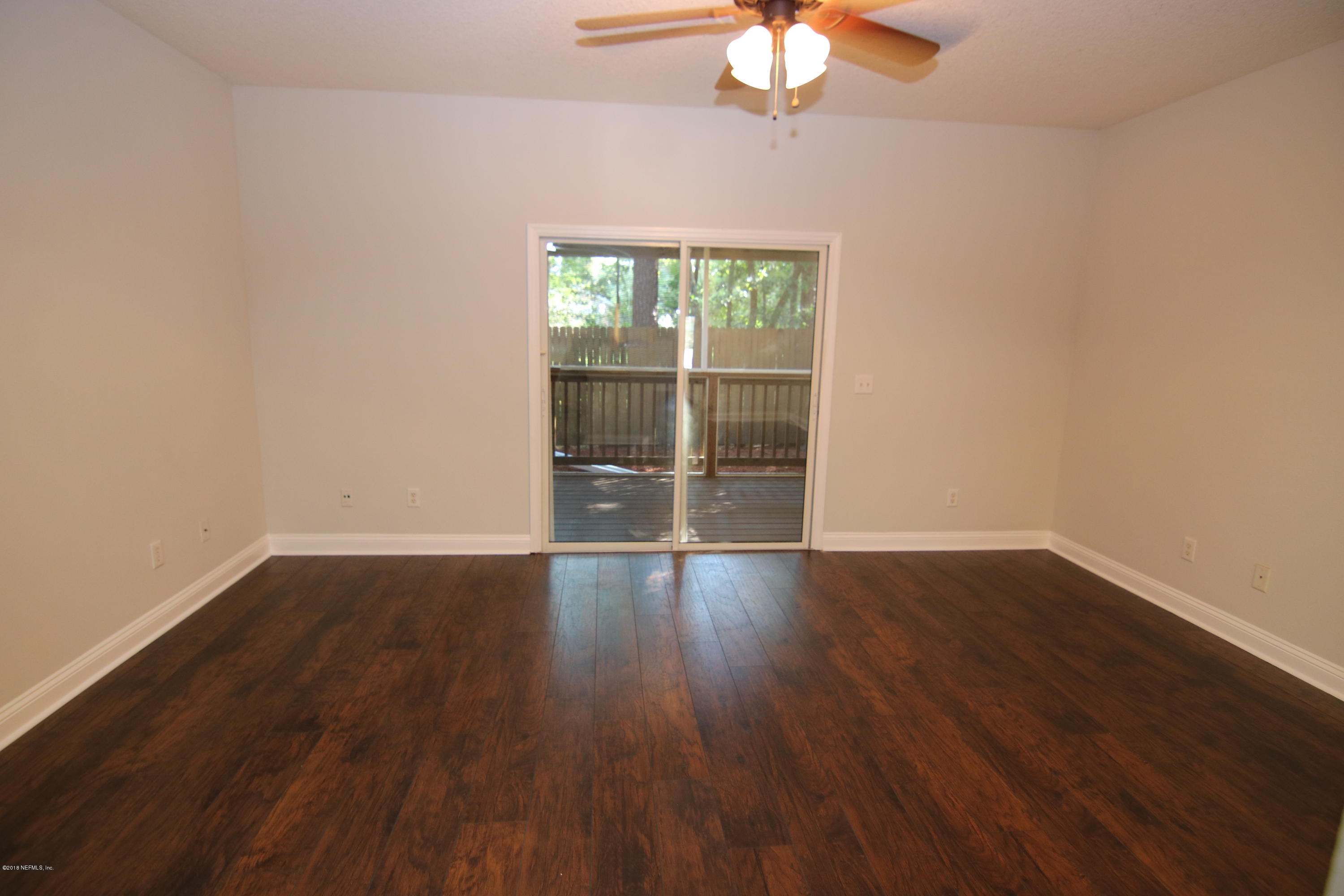 4661 Barnes Road South Jacksonville, FL 32207 - Photo 8 of 22 a view of an empty room with wooden floor and a window