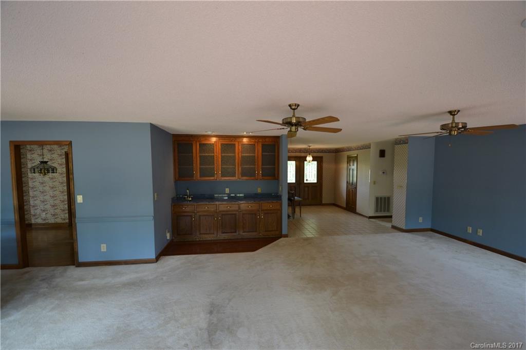 8147 Fairfield Forest Road Denver, NC 28037 - Photo 18 of 23 an empty room with a kitchen and chandelier fan