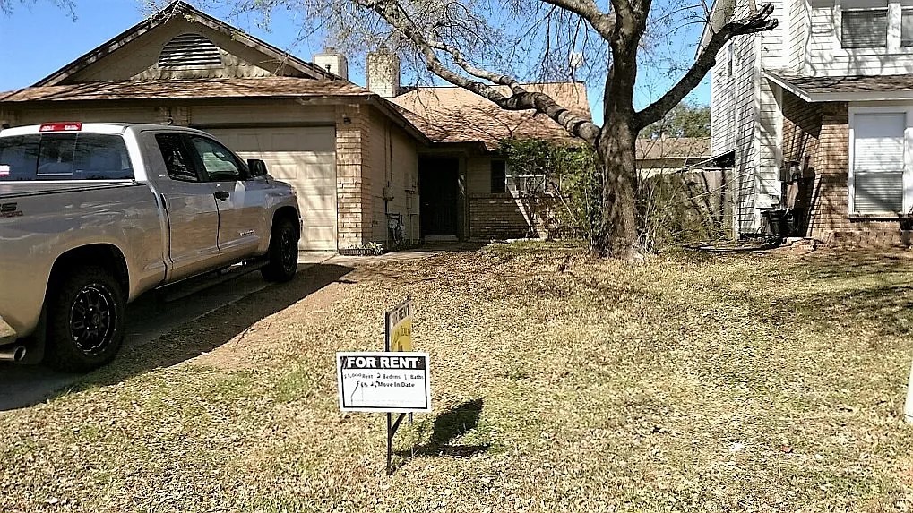 12214 Thompkins Drive, Unit B Austin, TX 78753 - Photo 3 of 13 View of side of home featuring brick siding, an attached garage, and driveway