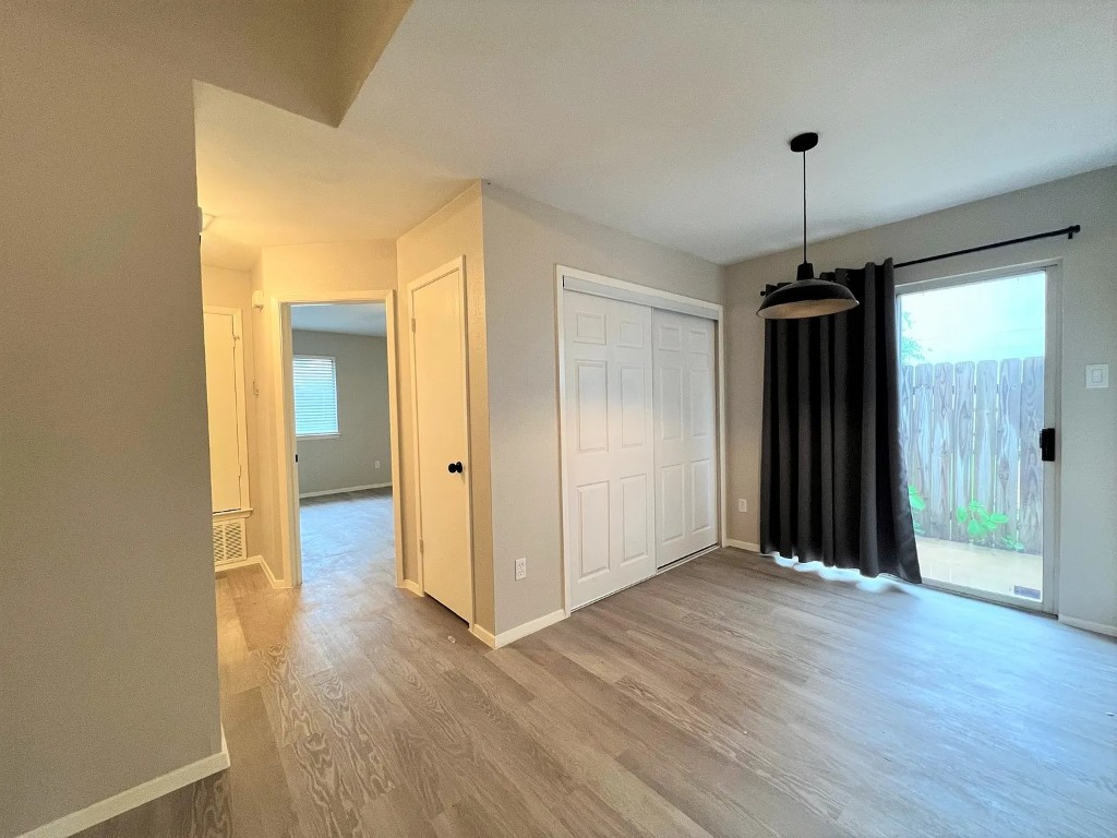 12214 Thompkins Drive, Unit B Austin, TX 78753 - Photo 8 of 13 Unfurnished dining area with baseboards and light wood-style floors