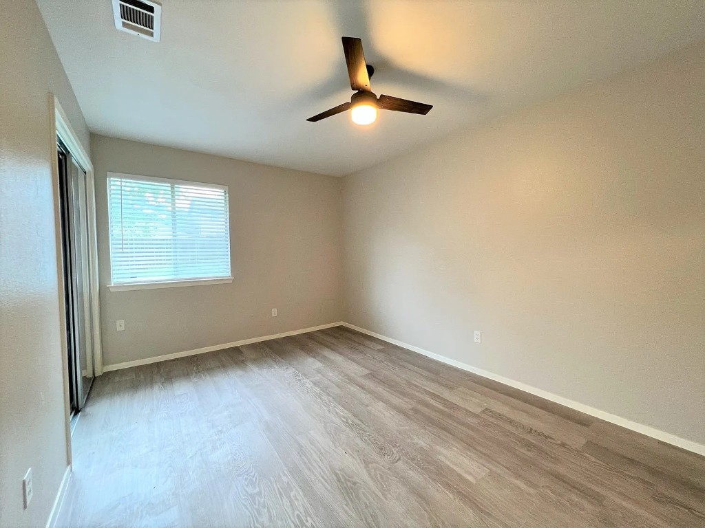 12214 Thompkins Drive, Unit B Austin, TX 78753 - Photo 9 of 13 Unfurnished bedroom with light wood-type flooring, ceiling fan, and a closet
