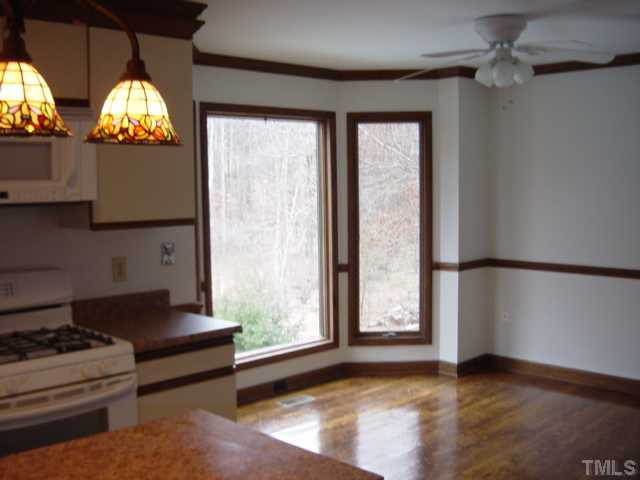 9512 Springdale Drive Raleigh, NC 27613 - Photo 3 of 11 Kitchen eating area with hardwood floors has a bay window overlooking the pool.