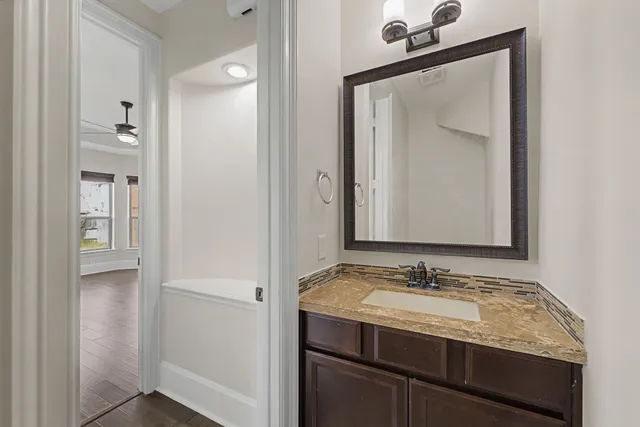 a bathroom with a granite countertop sink and a mirror