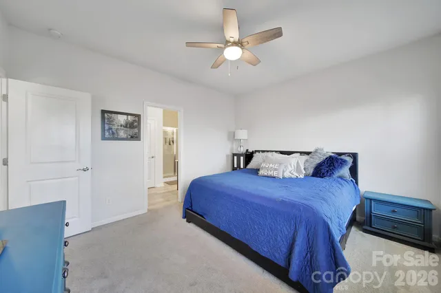 a spacious bedroom with a bed and a ceiling fan