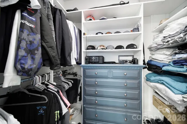 a view of walk in closet with clothes and shoes