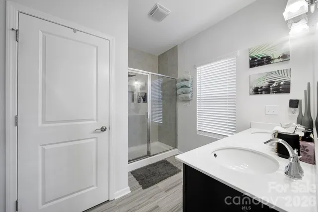 a bathroom with a sink shower and a mirror