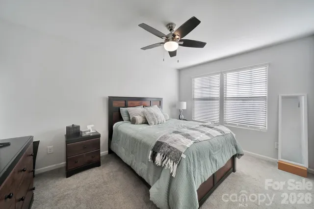 a bedroom with a bed and a ceiling fan