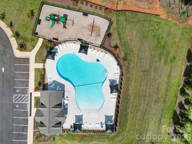 an aerial view of a house with a swimming pool and outdoor seating