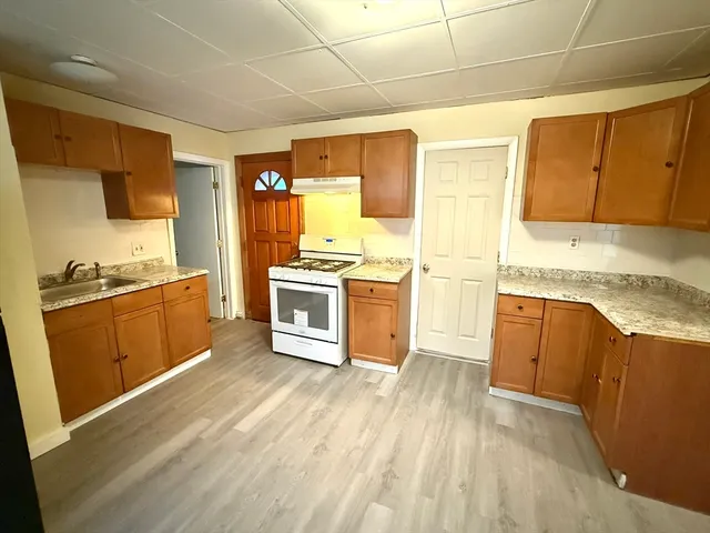 a kitchen with wooden floors and white appliances