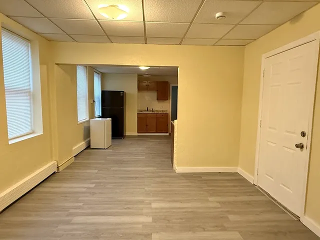 a view of a big room with wooden floor and windows