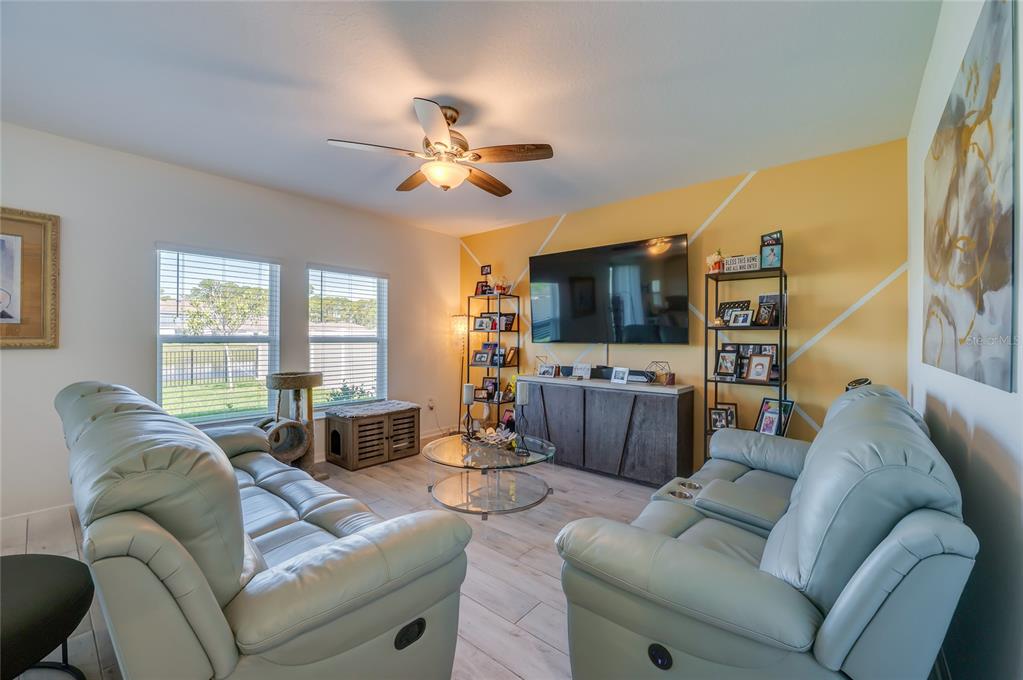 3986 Willowbrook Drive Edgewater, FL 32141 - Photo 11 of 57 a living room with furniture a flat screen tv and a large window