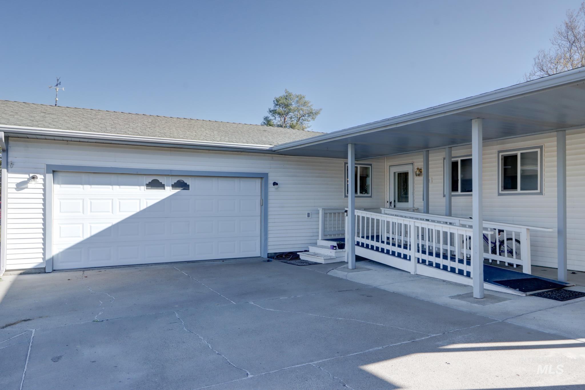 1302 Southwest 12th Street Ontario, OR 97914 - Photo 1 of 35 View of front facade featuring covered porch, driveway, a garage, and roof with shingles