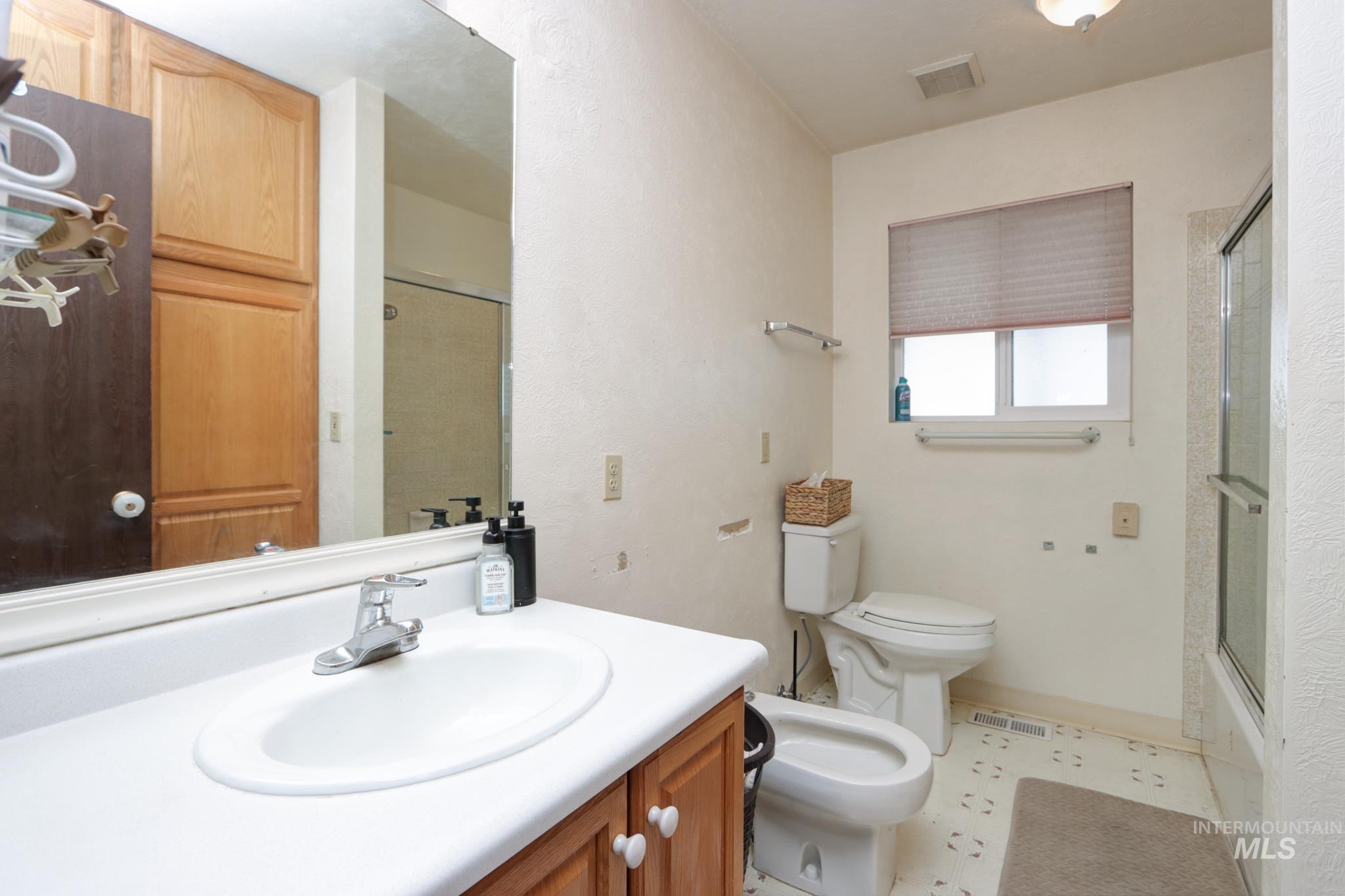 1302 Southwest 12th Street Ontario, OR 97914 - Photo 14 of 35 Bathroom with a bidet, vanity, and enclosed tub / shower combo