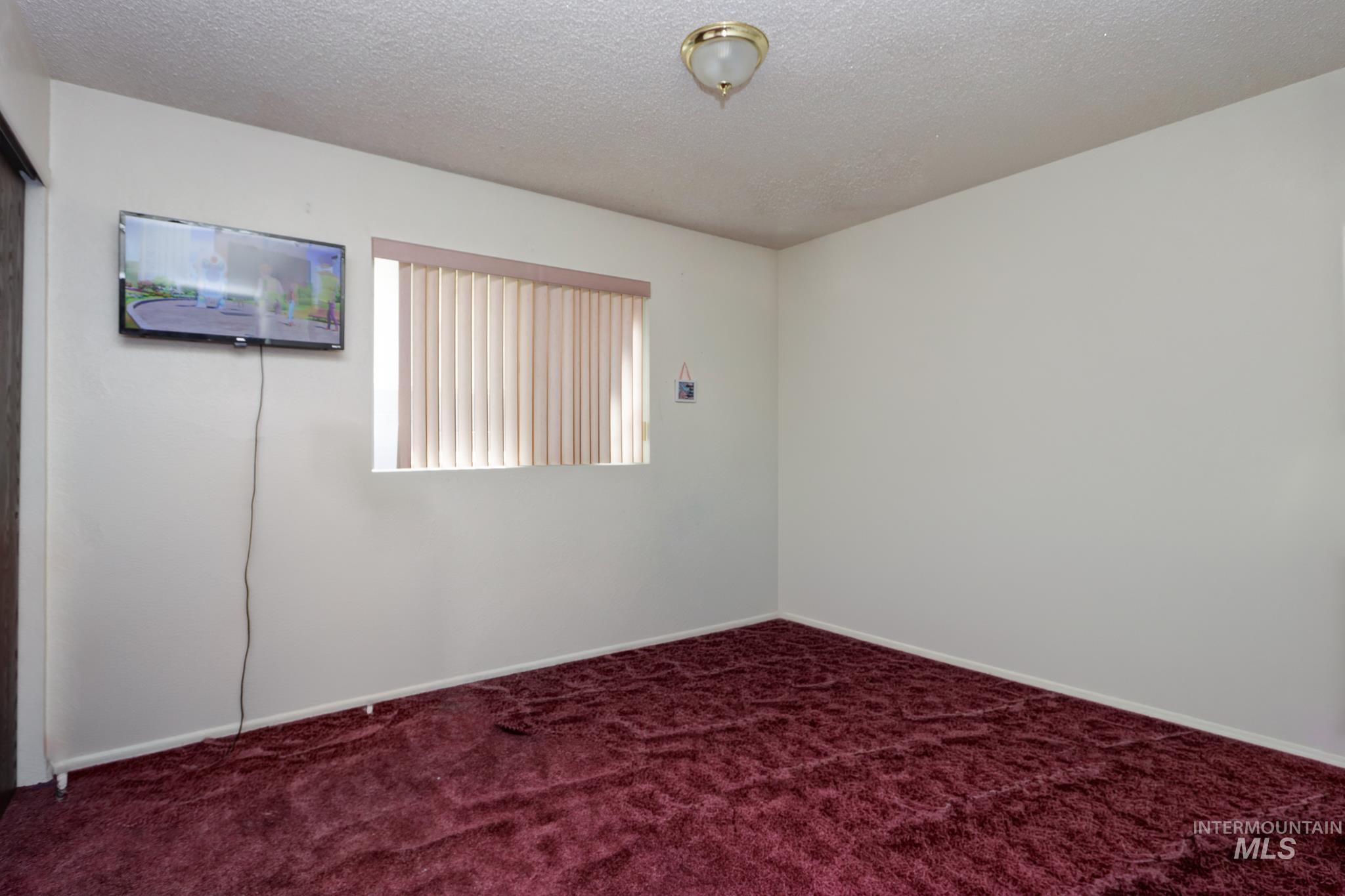 1302 Southwest 12th Street Ontario, OR 97914 - Photo 18 of 35 Empty room featuring a textured ceiling and dark carpet