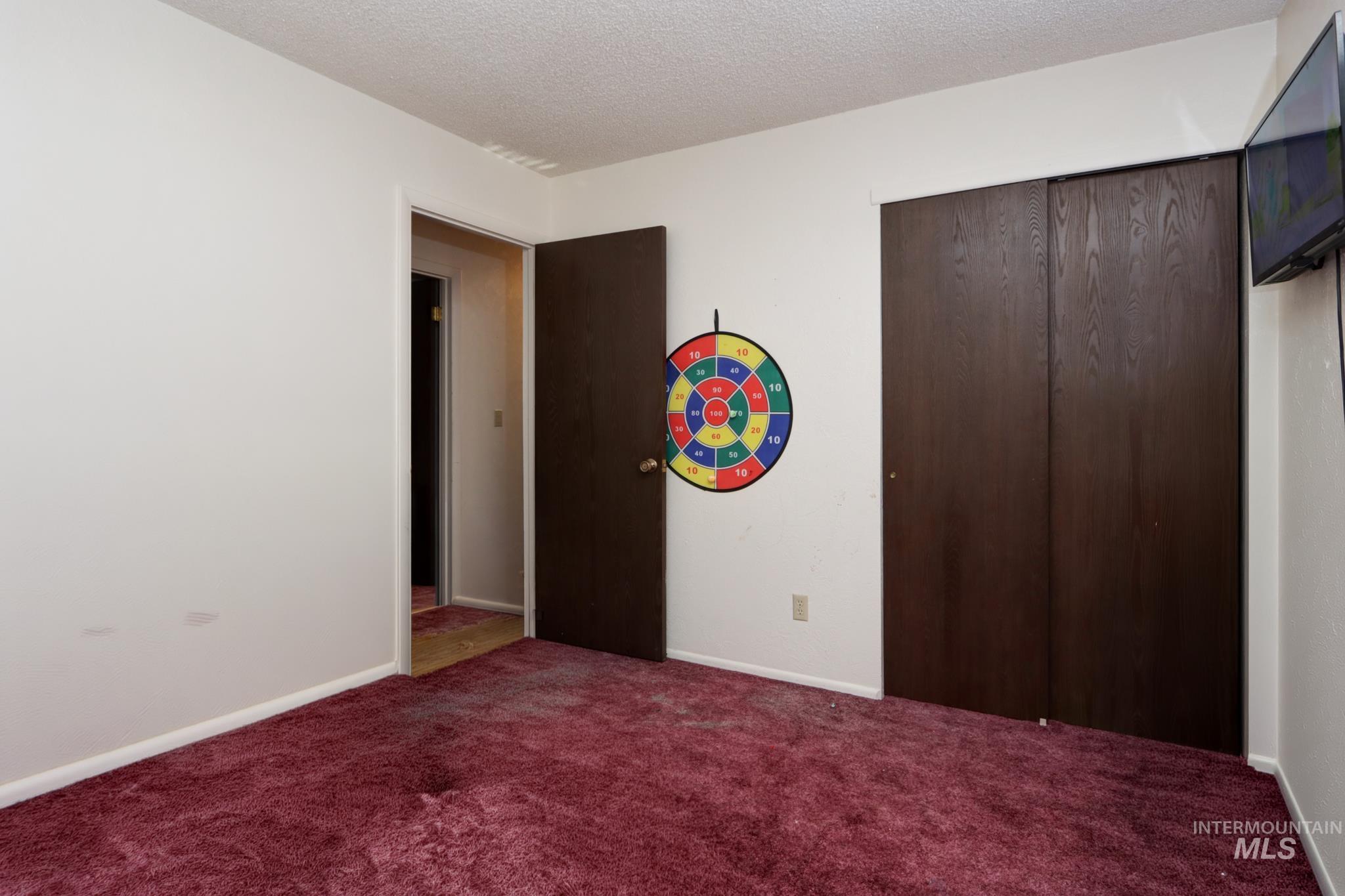 1302 Southwest 12th Street Ontario, OR 97914 - Photo 19 of 35 Bedroom featuring a textured ceiling, carpet flooring, and a closet