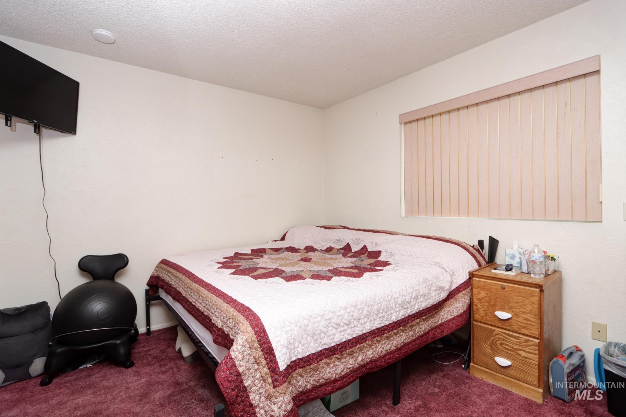 1302 Southwest 12th Street Ontario, OR 97914 - Photo 21 of 35 Bedroom featuring carpet and a textured ceiling