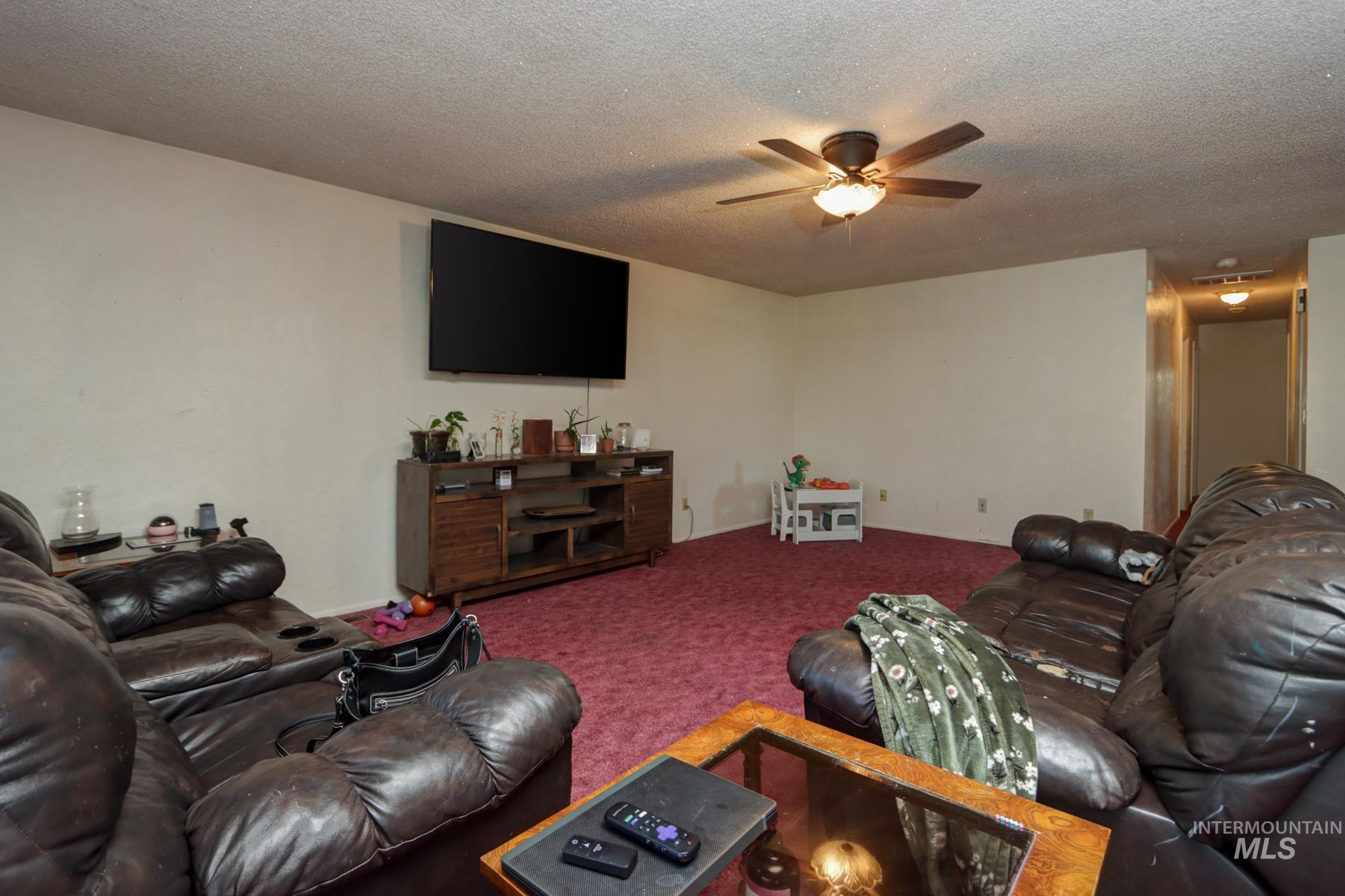 1302 Southwest 12th Street Ontario, OR 97914 - Photo 6 of 35 Living area with a ceiling fan, a textured ceiling, and carpet