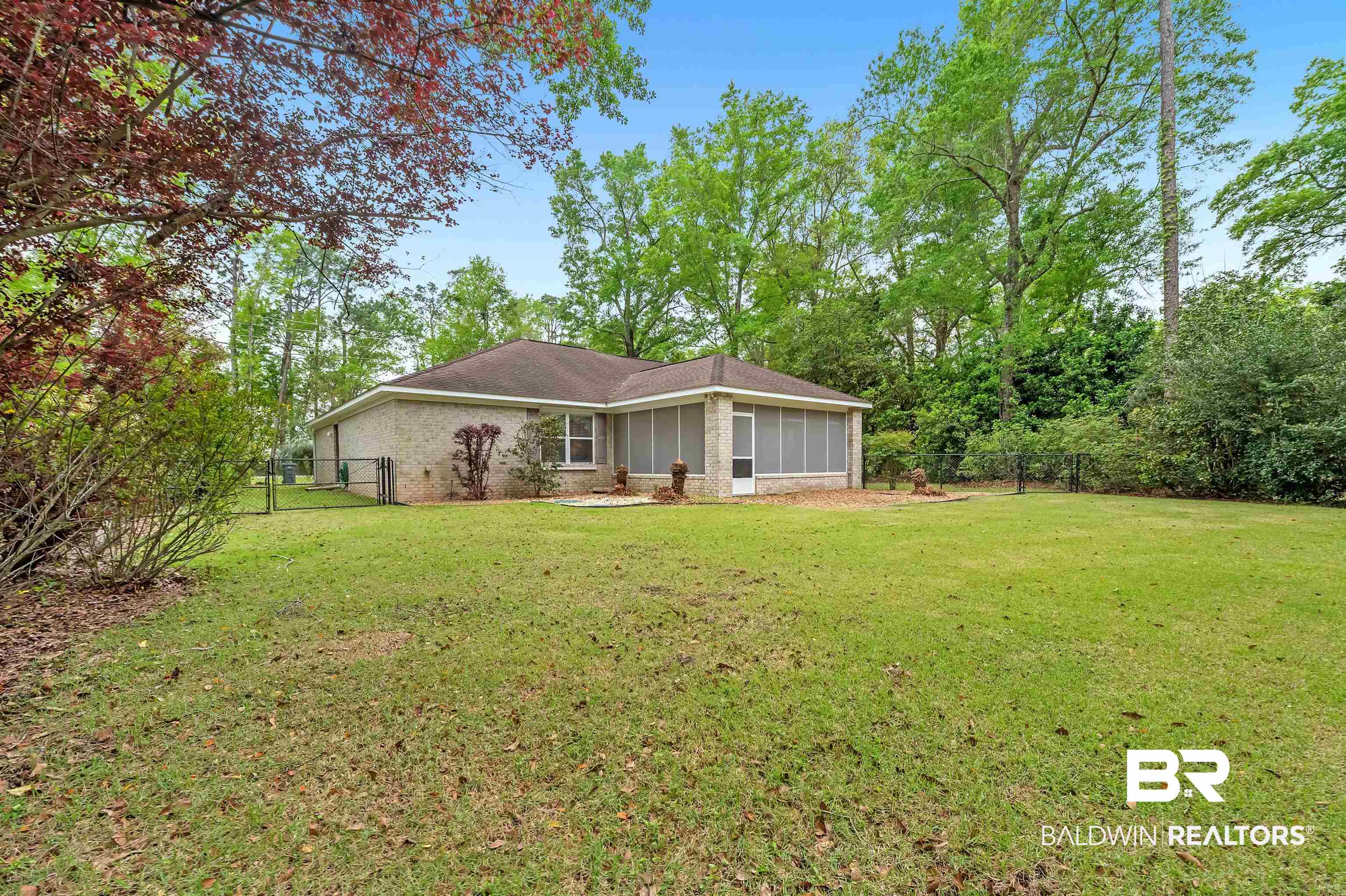 9908 Clarke Ridge Road Foley, AL 36535 - Photo 17 of 56 View of yard with a sunroom, a gate, and fence