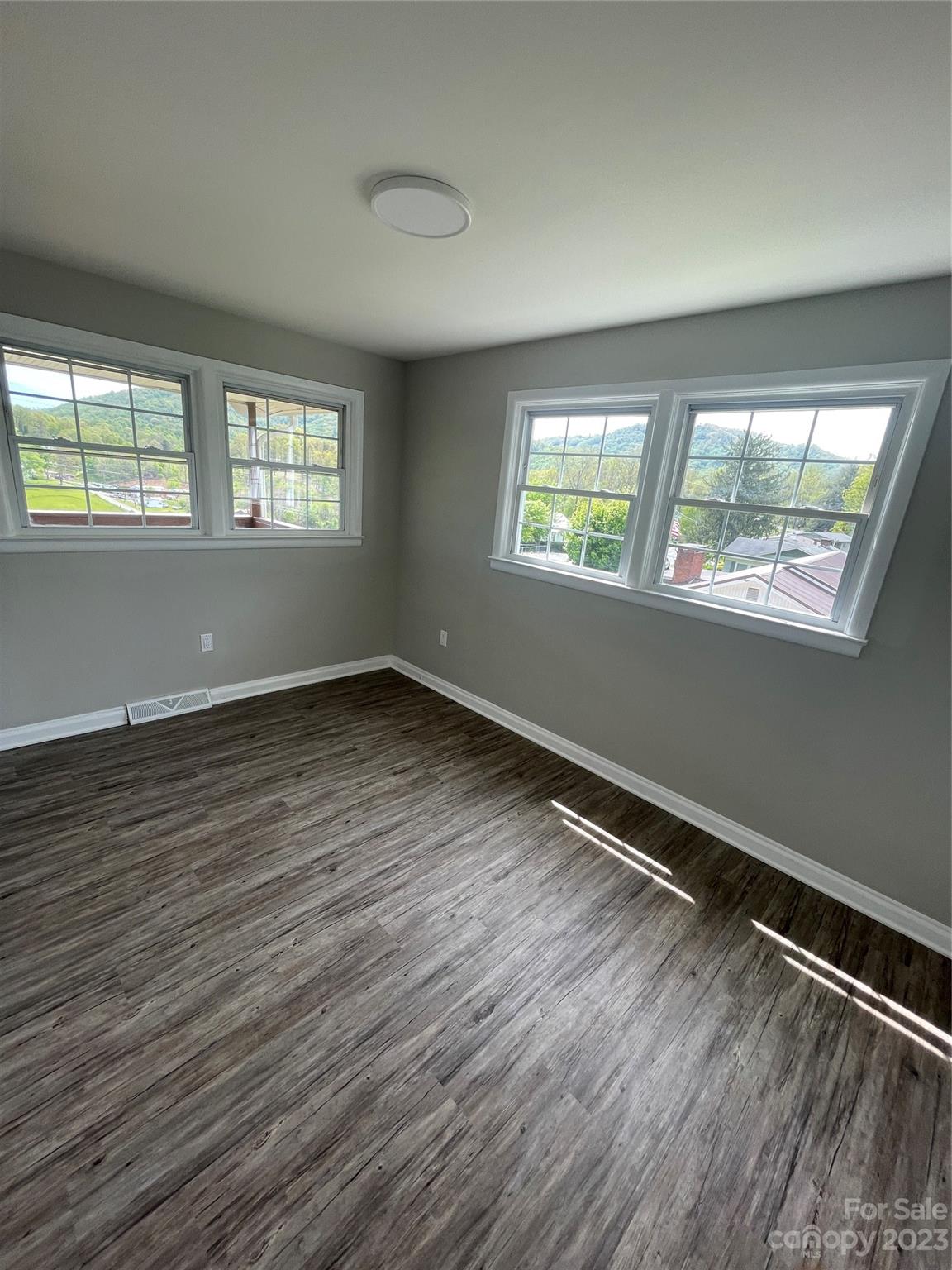 504 Mulberry Street Clyde, NC 28721 - Photo 9 of 18 a view of room with wooden floor and windows