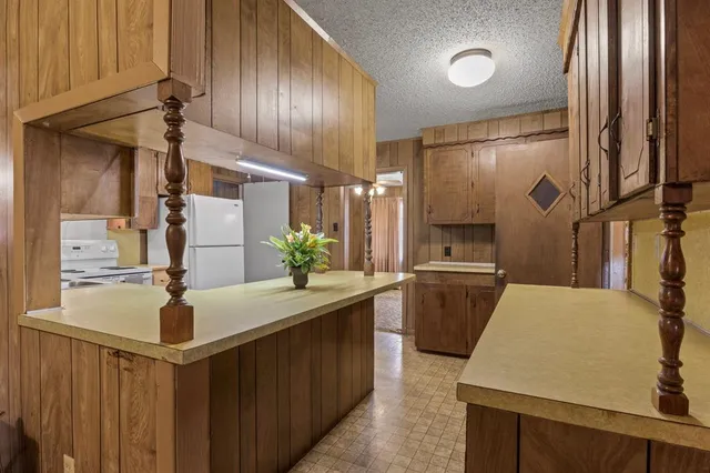 a kitchen with a sink refrigerator and cabinets