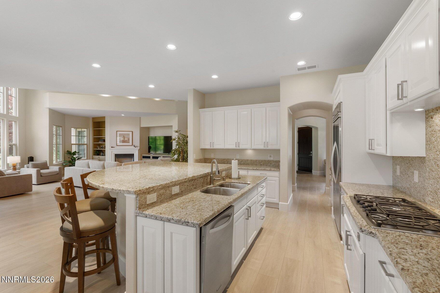 16925 Rue Du Parc Reno, NV 89511 - Photo 12 of 34 a kitchen with granite countertop kitchen island stainless steel appliances a sink a stove a refrigerator and cabinets